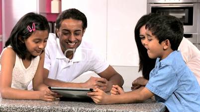 Young Ethnic Family with Wireless Tablet in Kitchen