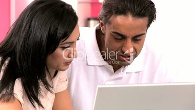 Young Ethnic Couple Online with Wireless Laptop