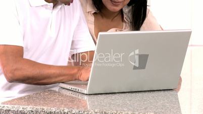 Asian Couple with Laptop Having Success Online