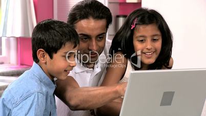 Young Asian Father & Children Using Laptop in Kitchen