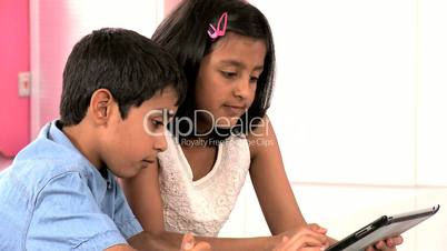 Asian Siblings Using Wireless Tablet