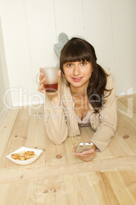 Young woman with tea and mobile phones at home