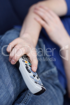 Guy watching tv with remote