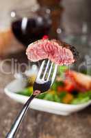 Steak auf einer Gabel über den Salat