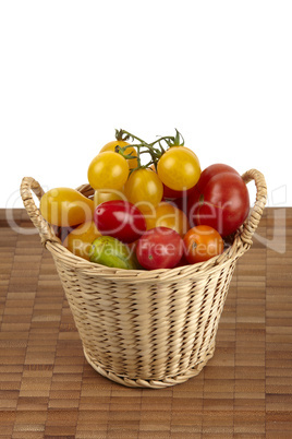 Korb mit frischen Bio Tomaten auf Bambusbrett - Basket of fresh organic tomatoes on bamboo board