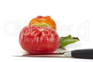 Vier große Bio-Tomaten mit Messer und Pfefferschale - Four large organic tomatoes with a knife and pepper dish
