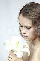 girl looks at a white flower