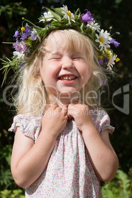 laughing little girl in flowers wreath