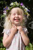 laughing little girl in flowers wreath