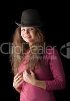 Beautiful girl in a hat on a black background