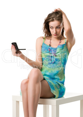 girl with a mirror sits on a chair