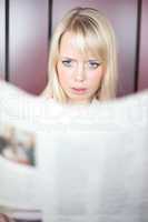 woman with a newspaper is frightened