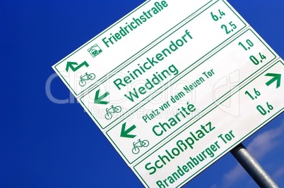 Straßenschild und Wegweiser in Berlin mit Schrift und Pfeilen