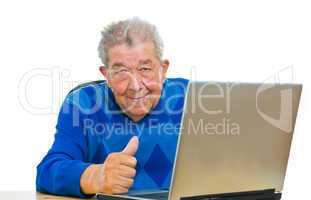 Senior sitzt am Laptop