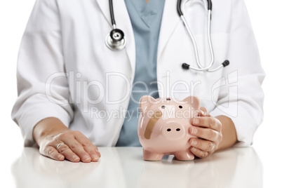 Doctor Holding Caring Hand on a Piggy Bank with Bandage