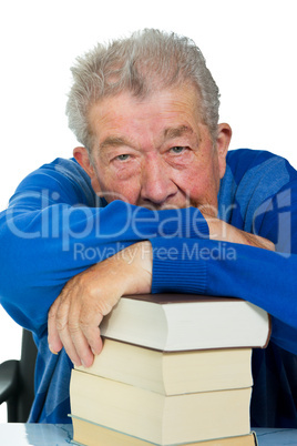 Senior ruht sich auf einem Bücherstapel aus
