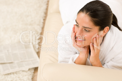 Attractive woman white bathrobe on sofa thinking Attractive woman white bathrobe on sofa thinking