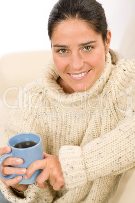 Winter portrait of happy woman holding cup of coffee