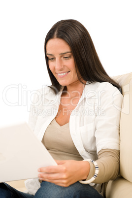 Woman with laptop sitting on couch smiling