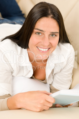Smiling mid-aged woman read book on sofa