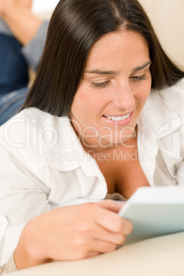Smiling mid-aged woman read book on sofa