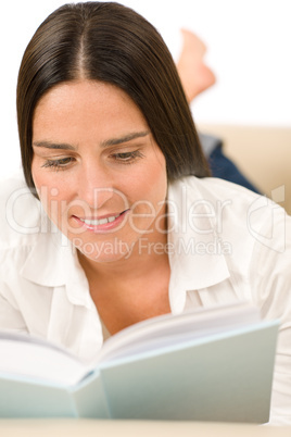 Attractive mid-aged woman read book on sofa