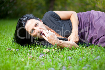 woman eating a plum on a meadow