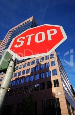 Stopschild in Frankfurt am Main mit Blick auf ein Hochhaus