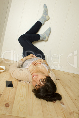 Young woman lying on the floor of the house