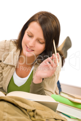 Student female teenager write homework with book