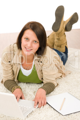 Student teenager girl looking laptop lying floor