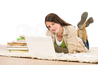 Student teenager girl looking laptop lying floor