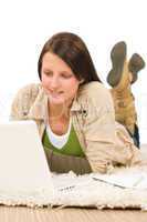 Student teenager girl typing laptop lying floor