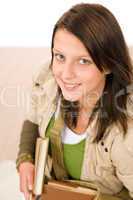 Student teenager girl holding books looking up