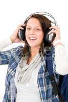 Smiling female teenager enjoy music headphones