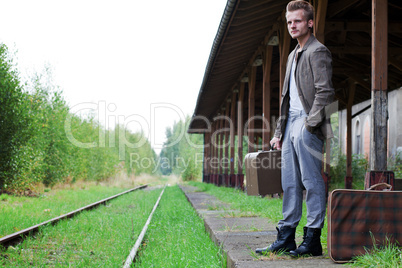 Mann steht am Bahngleis