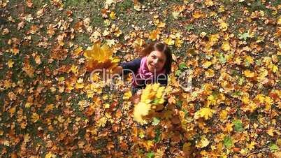a girl spinning with autumn leaves