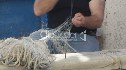 Fisherman repairs net
