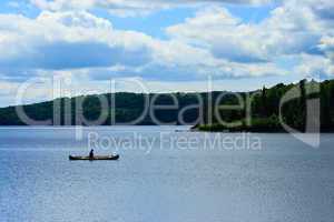 Canoeist Paddle on Calm Wilderness Lake