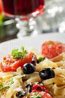 frische Pasta mit Tomaten und Oliven auf einem Teller