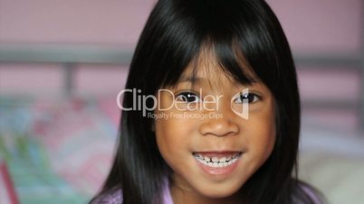 Asian Girl Wiggling Her First Loose Tooth