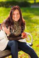 Autumn attractive woman eat apple sunset park