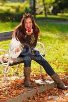 Autumn attractive woman eat apple sunset park