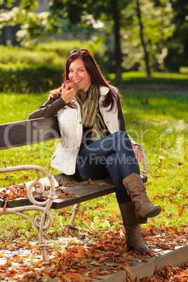 Autumn attractive woman eat apple sunset park