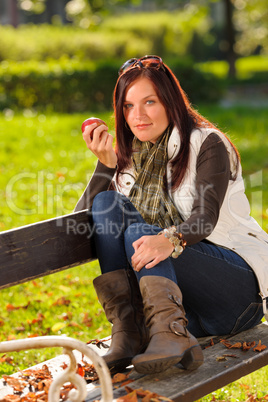 Autumn attractive woman eat apple sunset park