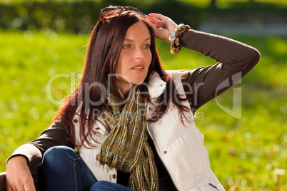 Autumn sunset park woman sitting on bench
