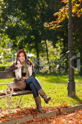 Autumn beautiful woman sit on bench park