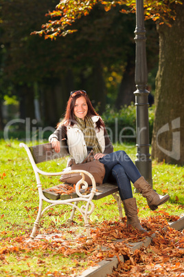 Autumn beautiful woman sit on bench park