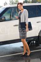 Elegant businesswoman stand by luxury car calling