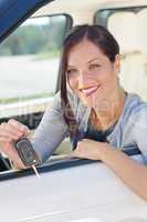 Attractive businesswoman in new car showing keys